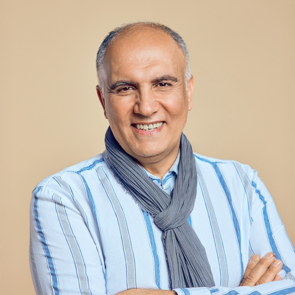 Portrait von Atila, Mitarbeiter bei Michaelis Friseure – professioneller Teamauftritt vor neutralem Hintergrund