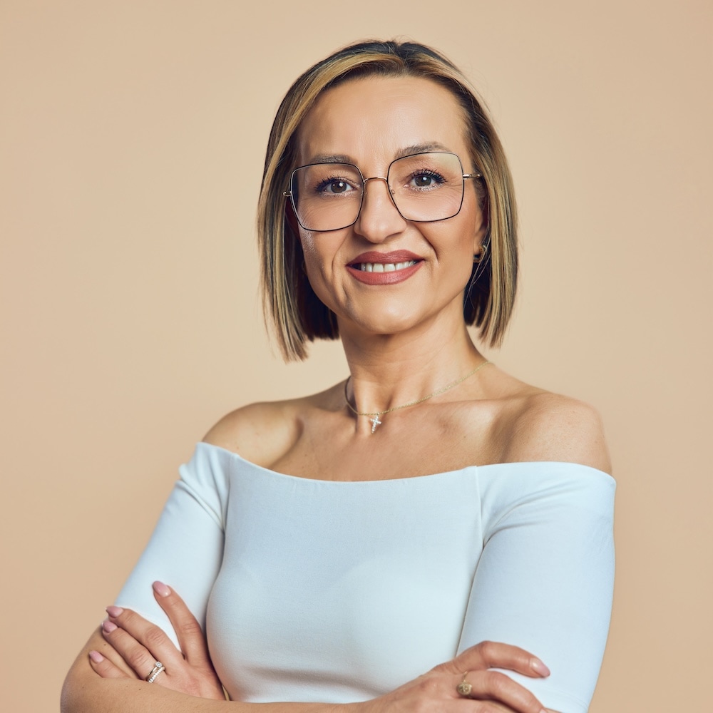 Portrait von Jola, Mitarbeiterin bei Michaelis Friseure – professioneller Teamauftritt vor neutralem Hintergrund