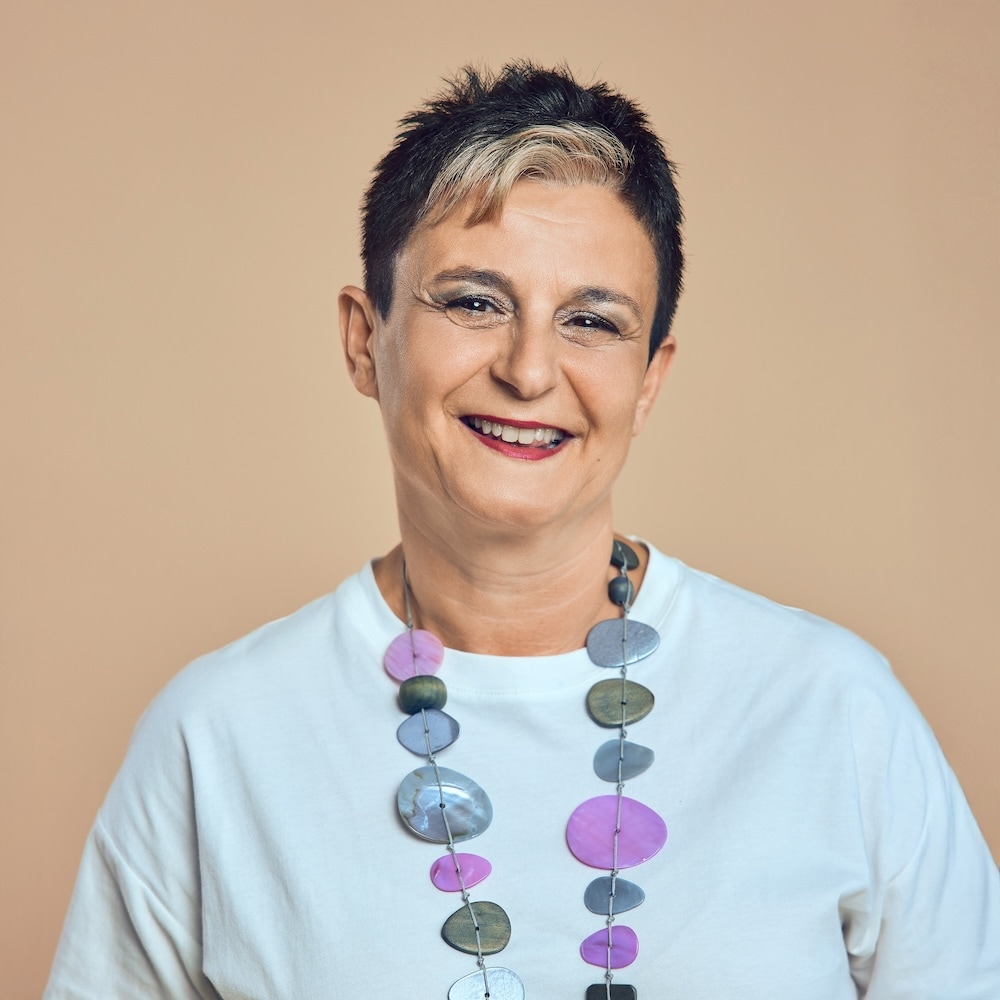 Portrait von Maria, Mitarbeiterin bei Michaelis Friseure – professioneller Teamauftritt vor neutralem Hintergrund